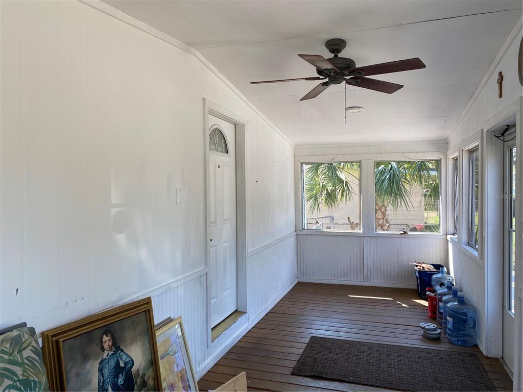 A sunroom features wood flooring, white paneled walls, a ceiling fan, and several large windows — 313 S OBSERVATORY DRIVE, ORLANDO, FL