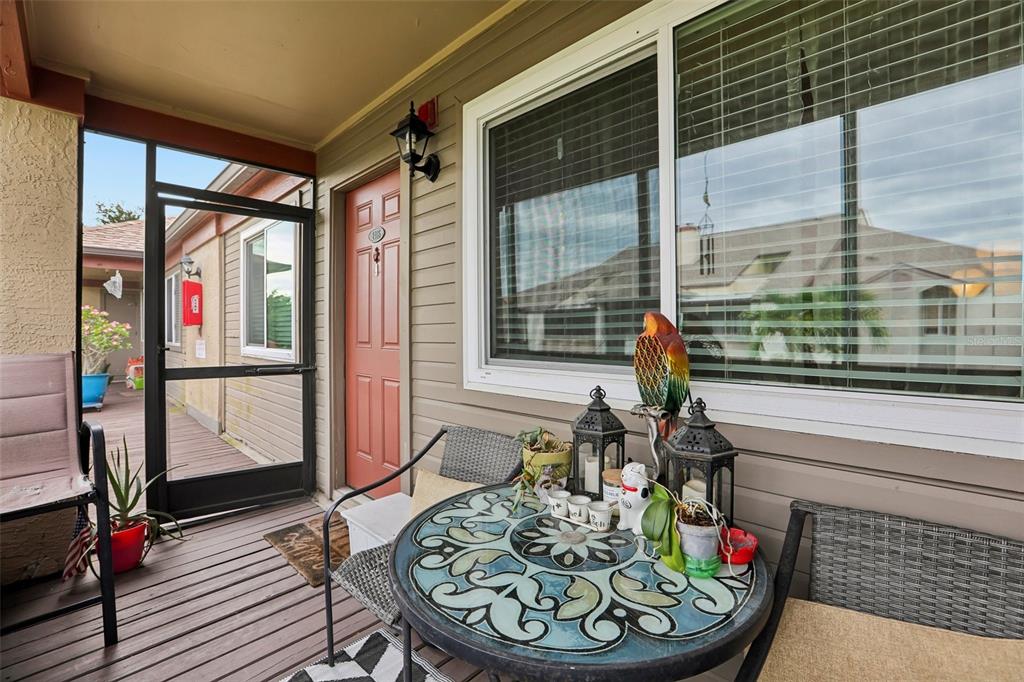 A living room features a brown sectional sofa, a television on a white console, and a ceiling fan — 10263 GANDY BOULEVARD N UNIT 2416, ST PETERSBURG, FL