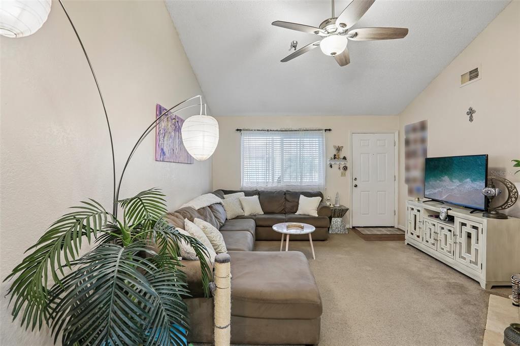 A dining area features a round table, white chairs, a brick wall, and a crystal chandelier — 10263 GANDY BOULEVARD N UNIT 2416, ST PETERSBURG, FL