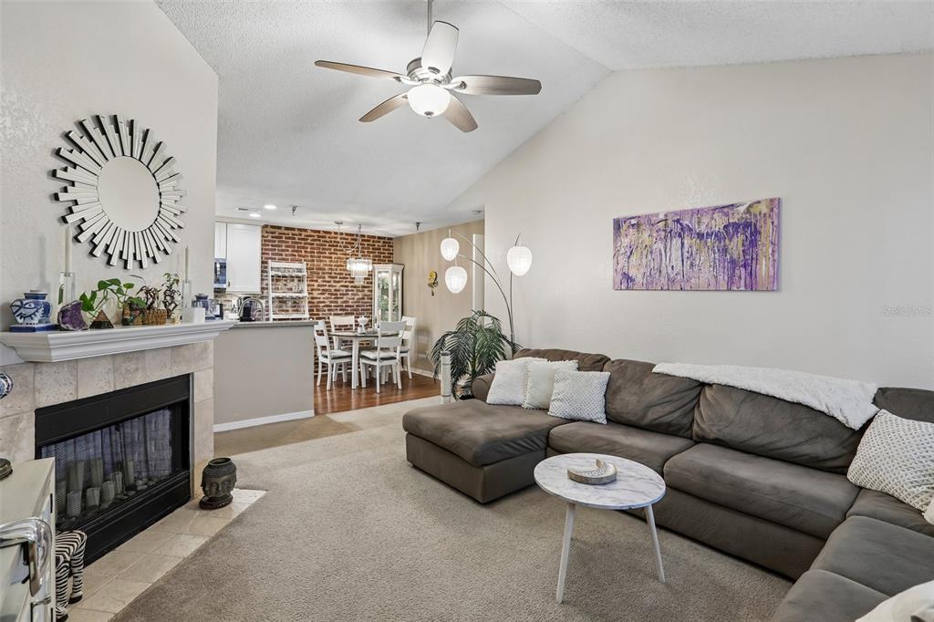 A kitchen and dining area features a brick accent wall, white cabinets, and a chandelier — 10263 GANDY BOULEVARD N UNIT 2416, ST PETERSBURG, FL