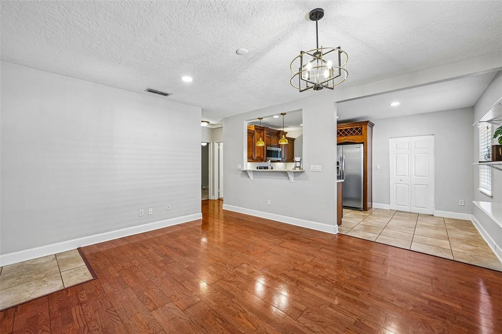 A living room with hardwood floors opens to a kitchen featuring a breakfast bar — 3924 W BAY VIEW AVENUE, TAMPA, FL