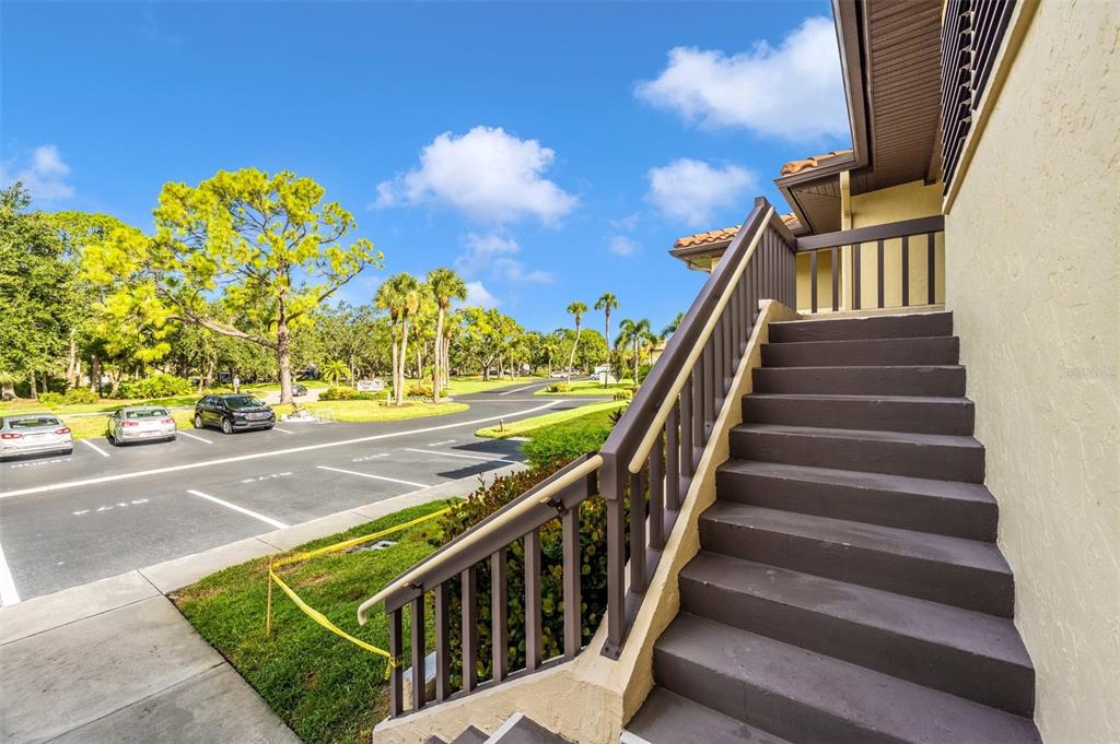 An exterior view of a building with a staircase leading to an upper level — 5178 LAKE VILLAGE DRIVE UNIT 86, SARASOTA, FL