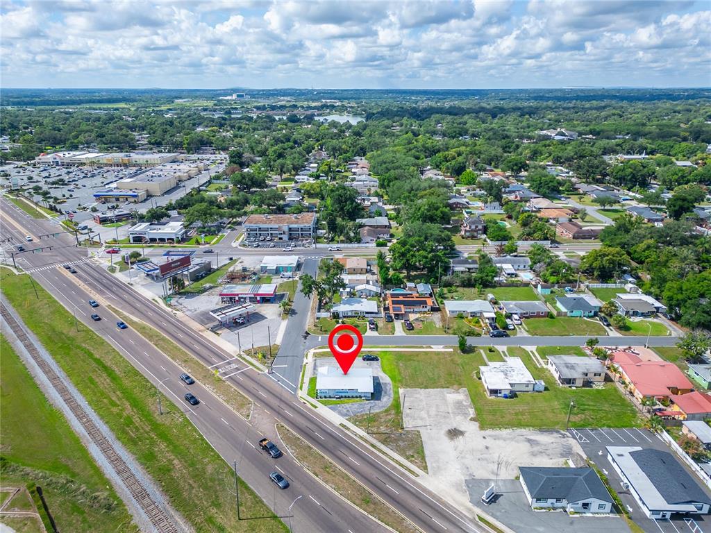 Aerial view of a commercial building with a red location pin on a highway — 1233 BARTOW ROAD, LAKELAND, FL