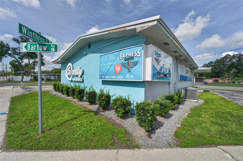 A light blue commercial building with signage stands at the corner of two intersecting streets — 1233 BARTOW ROAD, LAKELAND, FL