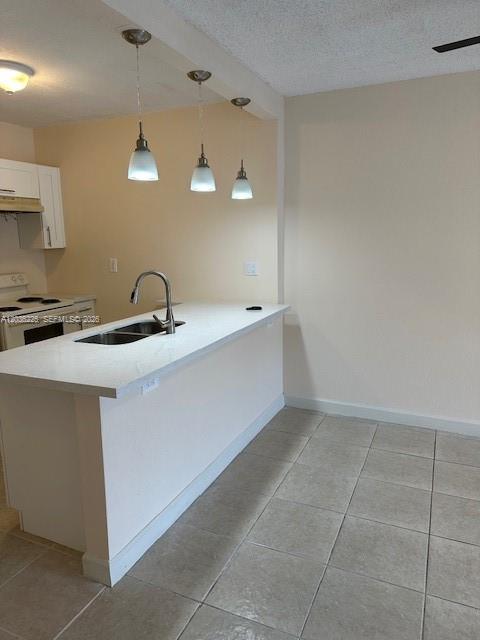 A kitchen features a white countertop island with a sink and three pendant lights above — 10900 SW 104th St # 118, Miami FL 33176, MIAMI, FL