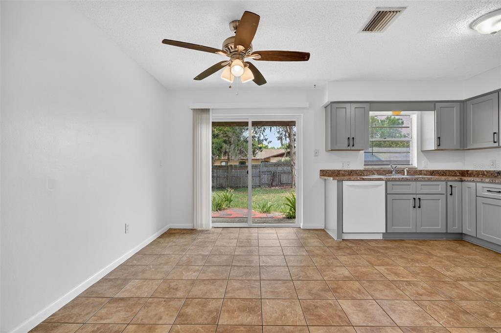 A dining area with tile floors, a ceiling fan, and a view of the backyard — 2319 S TENNYSON POINT, HOMOSASSA, FL