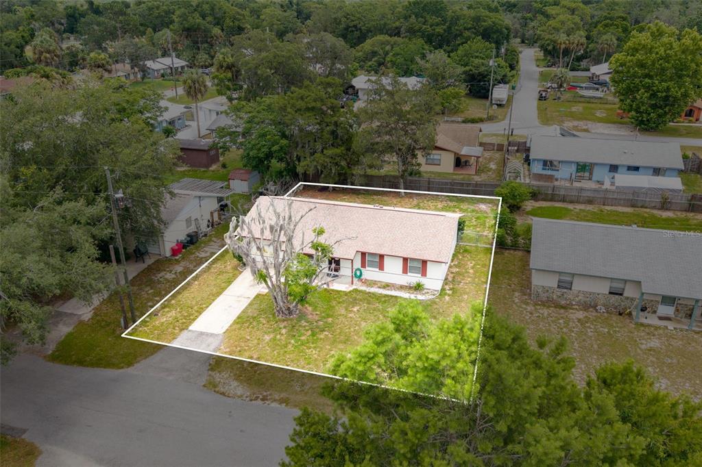 An aerial view shows a single-story house with a white exterior and a fenced yard — 2319 S TENNYSON POINT, HOMOSASSA, FL