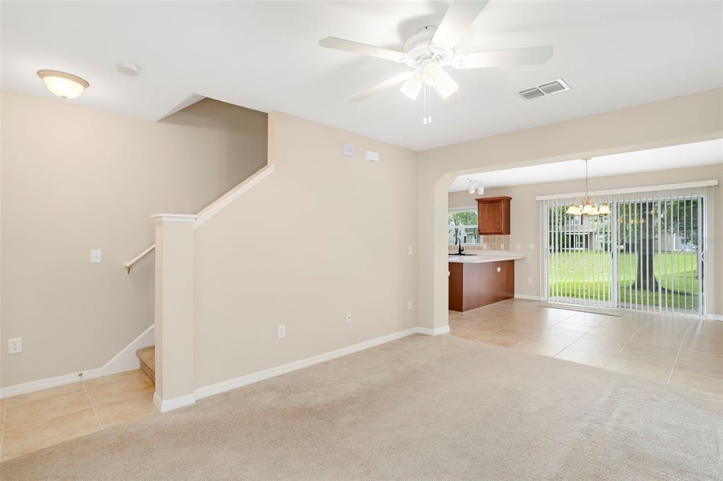 An interior view shows a carpeted living area with a staircase and an adjacent kitchen — 2907 BEAR OAK DRIVE, VALRICO, FL