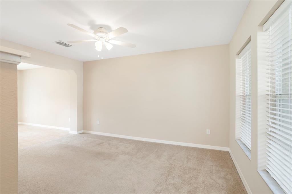 A living room features a beige sofa, a black coffee table, and a white armchair — 2907 BEAR OAK DRIVE, VALRICO, FL