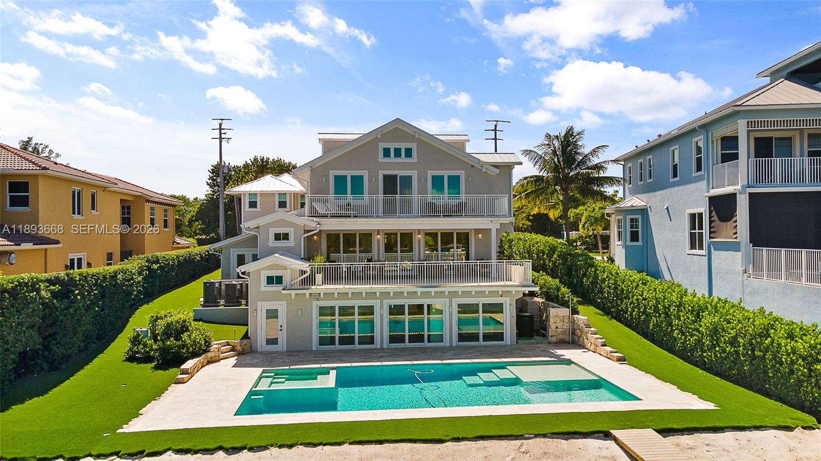 A three-story house with balconies, a swimming pool, and a manicured lawn — 18119 SE Federal Hwy, Jupiter FL 33469, JUPITER, FL