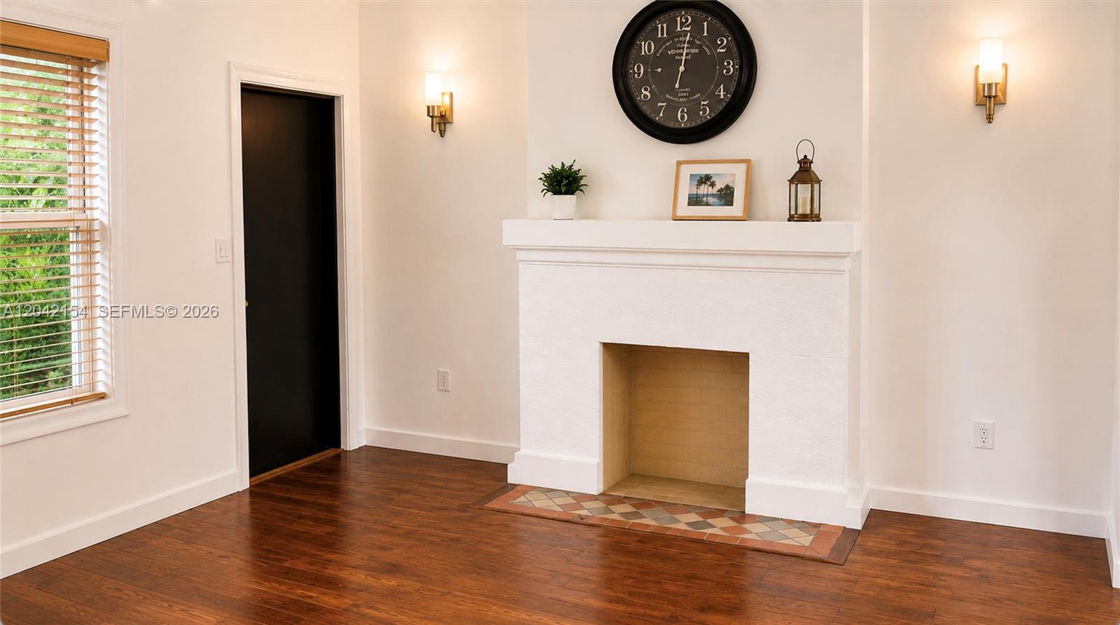 A room features a white fireplace, dark wood floors, a large wall clock, and windows — 3612 SW 1st Ave, Miami FL 33145, MIAMI, FL