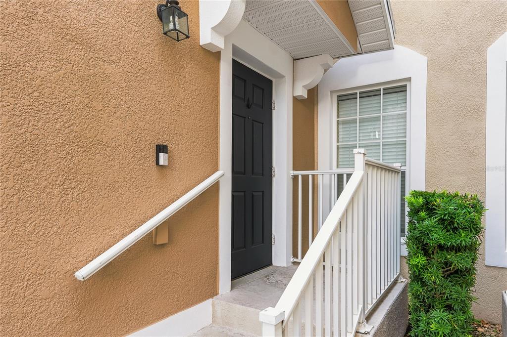 A black front door with a white railing and a small porch light — 417 HILGARD COVE UNIT ., SANFORD, FL