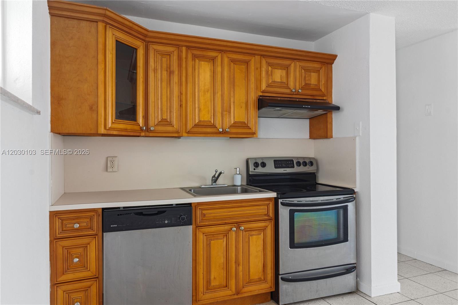 A kitchen features wood cabinets, stainless steel appliances, and a light-colored countertop — 1750 James Ave # 9C, Miami Beach FL 33139, MIAMI BEACH, FL