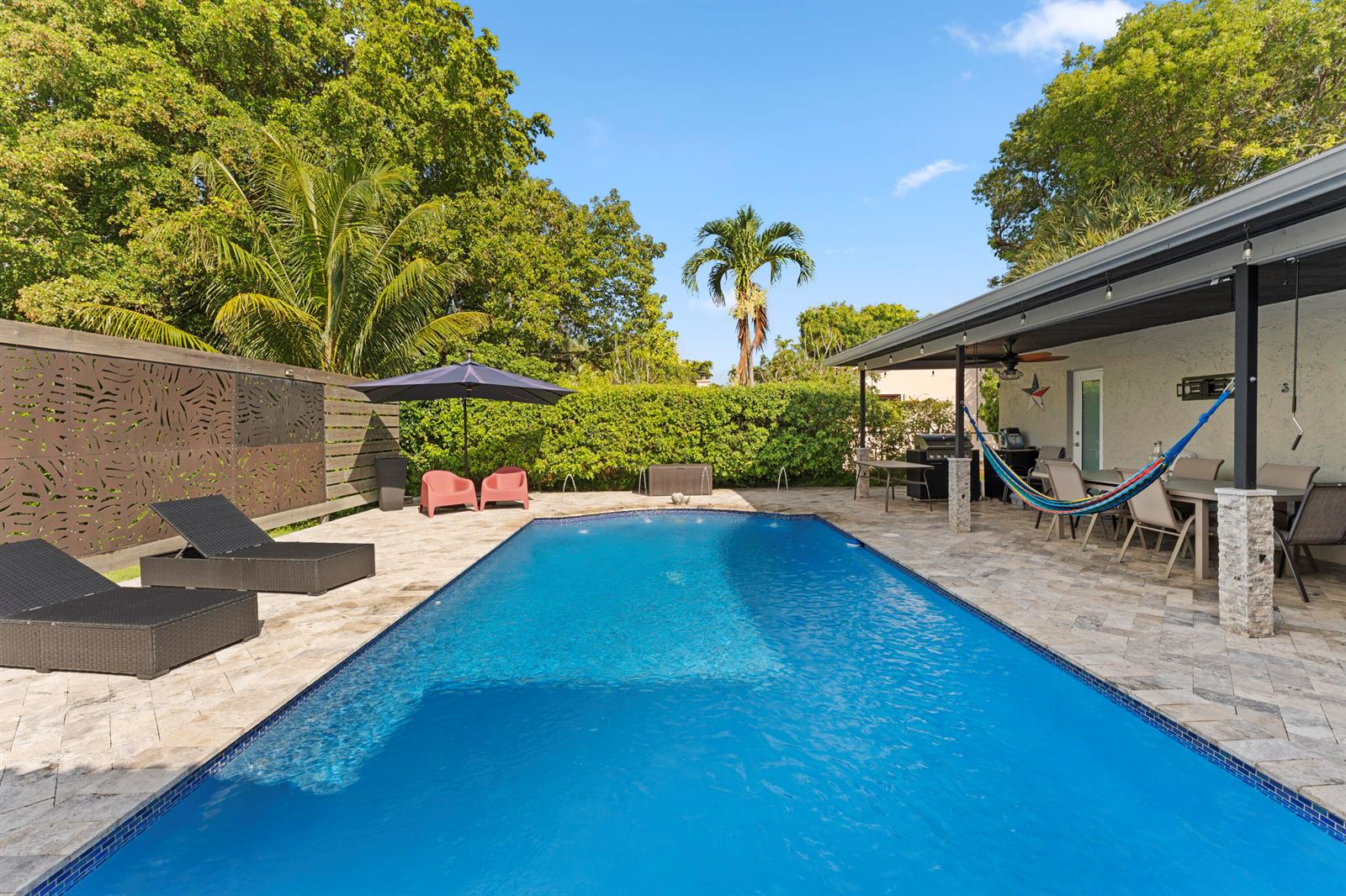 A backyard swimming pool with lounge chairs, a patio, and a covered dining area — 4080 Lake Drive, Coconut Creek FL 33066, COCONUT CREEK, FL