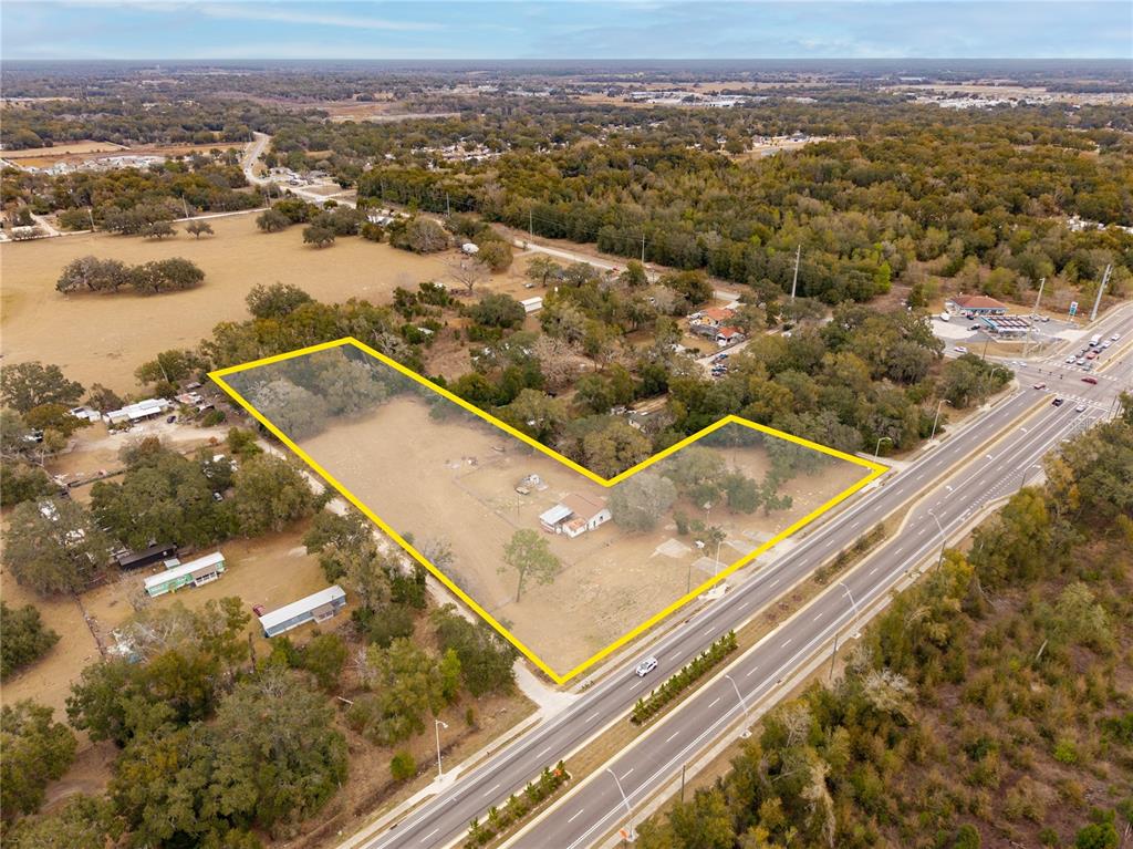 An aerial view shows a large, L-shaped parcel of land with a small building — 36845 CLINTON AVENUE, DADE CITY, FL