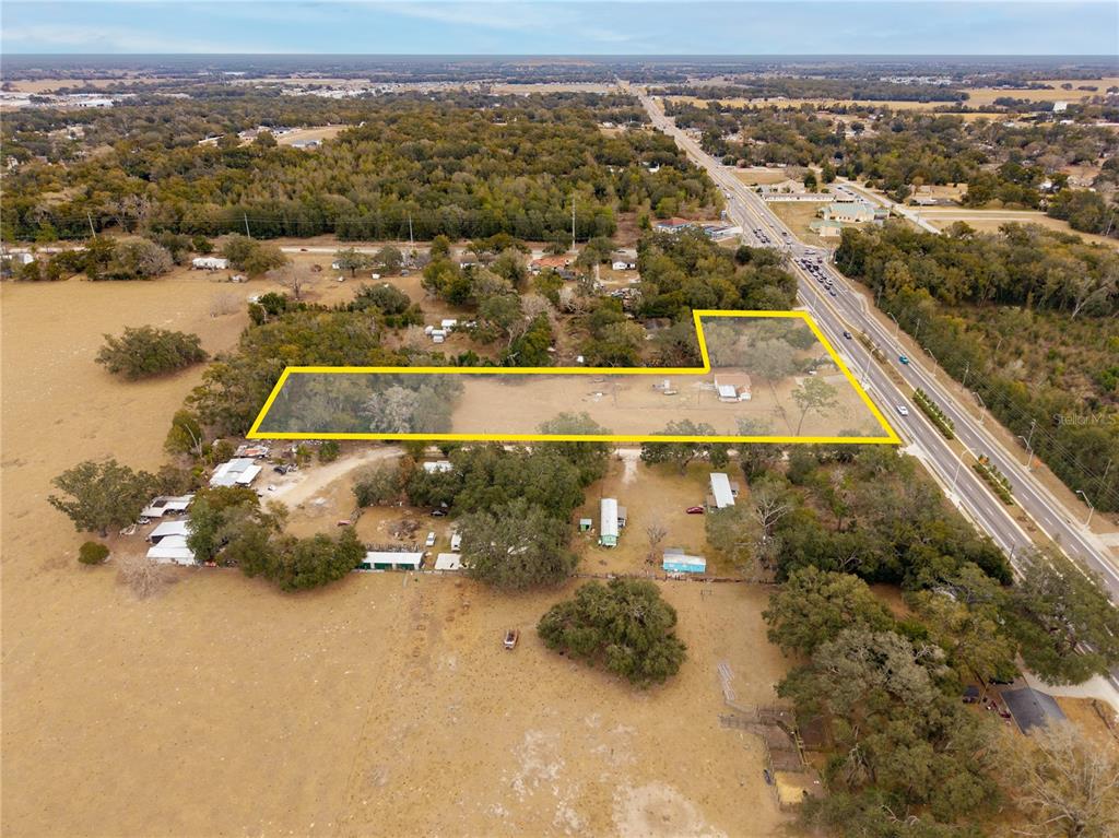 An aerial view shows a rectangular property outlined in yellow next to a highway — 36845 CLINTON AVENUE, DADE CITY, FL