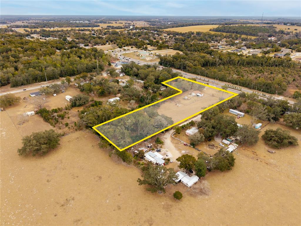 An aerial view shows a large, L-shaped residential lot outlined in yellow — 36845 CLINTON AVENUE, DADE CITY, FL