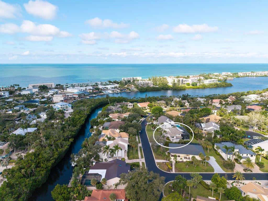 An aerial view shows a residential neighborhood with a circled house near a coastal waterway — 3210 BAYOU SOUND, LONGBOAT KEY, FL