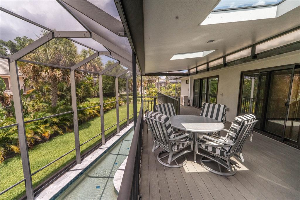 A screened-in balcony features a small lap pool, outdoor dining furniture, and a skylight — 3210 BAYOU SOUND, LONGBOAT KEY, FL