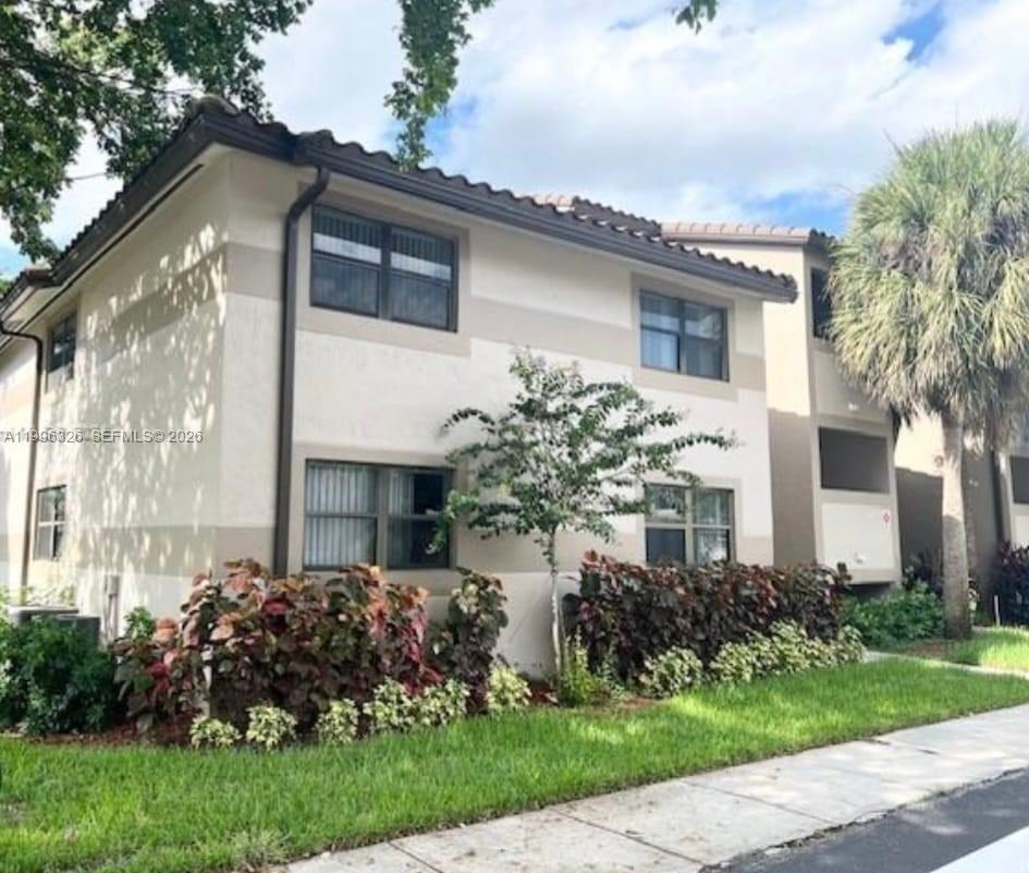 A two-story stucco apartment building with a tile roof, landscaping, and a palm tree — 9885 Nob Hill Ct # 9885, Sunrise FL 33351, SUNRISE, FL
