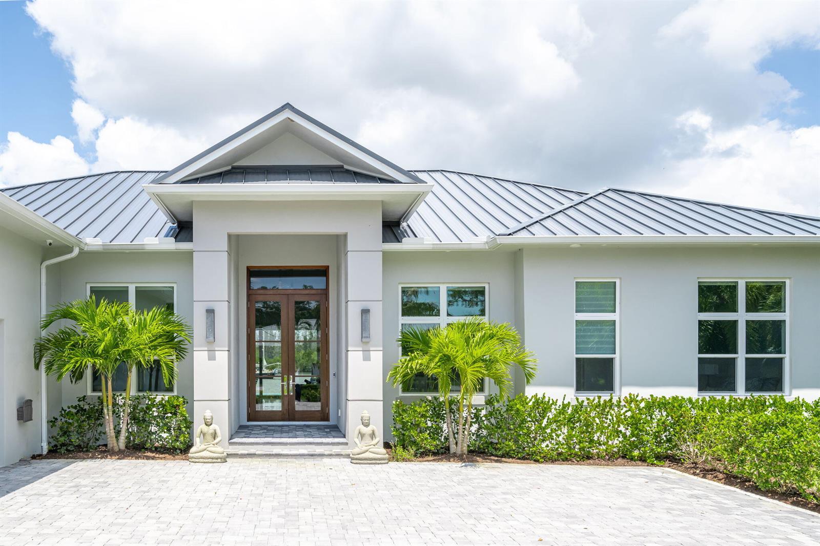 A single-story house with a metal roof, white stucco walls, and two palm trees — 3937 Indian River Drive E, Vero Beach FL 32963, VERO BEACH, FL