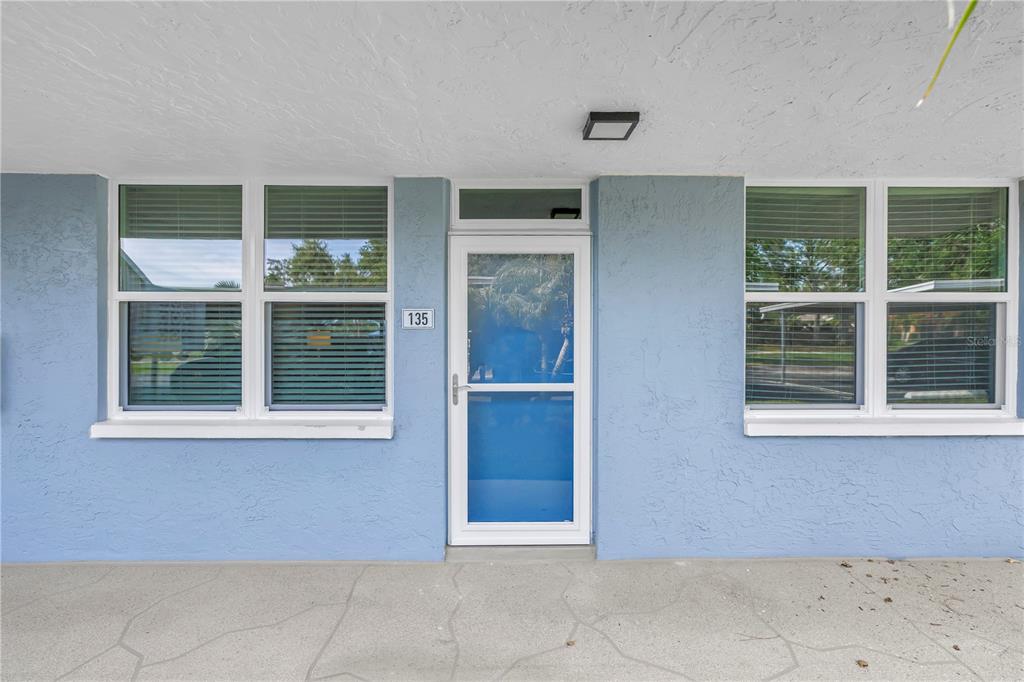The exterior of a blue building features a central door labeled 135 and two windows — 4715 BAY STREET NE UNIT 135, ST PETERSBURG, FL