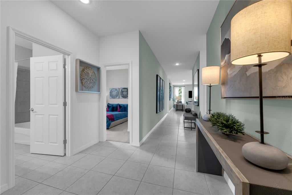 A tiled hallway features a console table with lamps and doorways leading to other rooms — 1718 FLAG STREET, HAINES CITY, FL