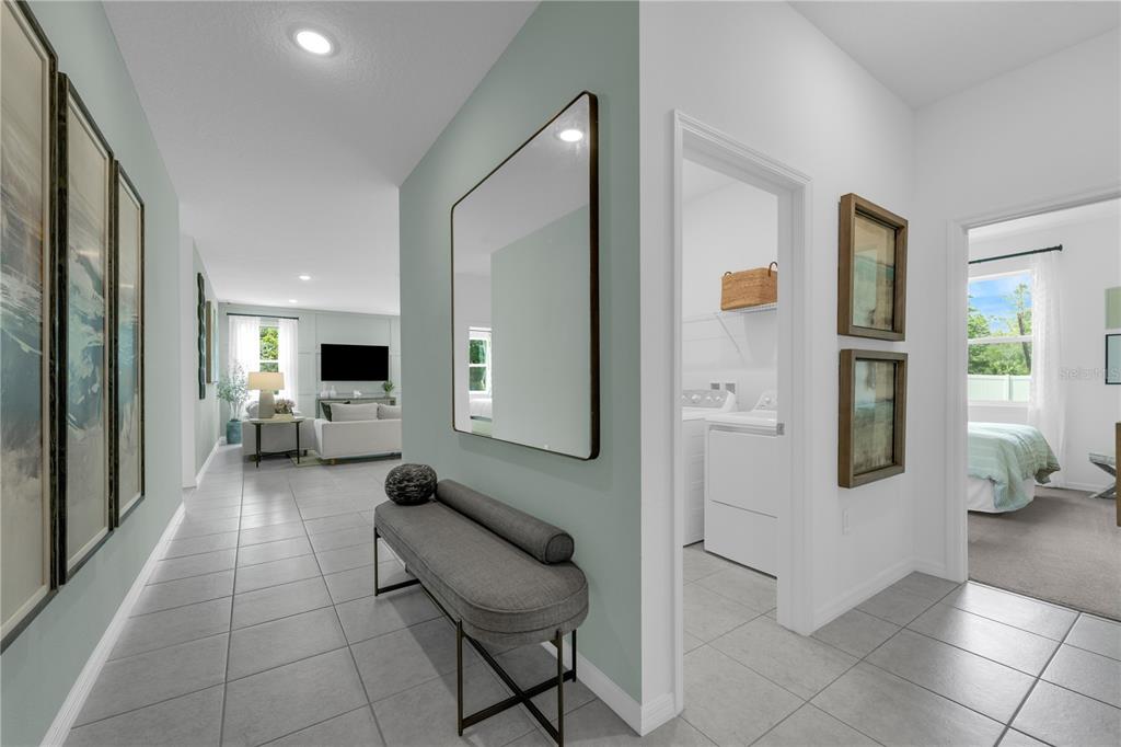 A hallway with tile flooring leads to a living area, featuring a bench and mirror — 1718 FLAG STREET, HAINES CITY, FL