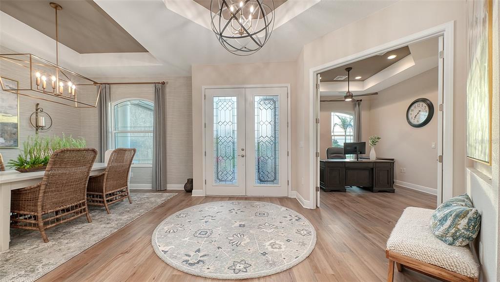 A foyer with a circular rug, double glass doors, a dining area, and a home office — 3554 RECURVE CIRCLE, SARASOTA, FL