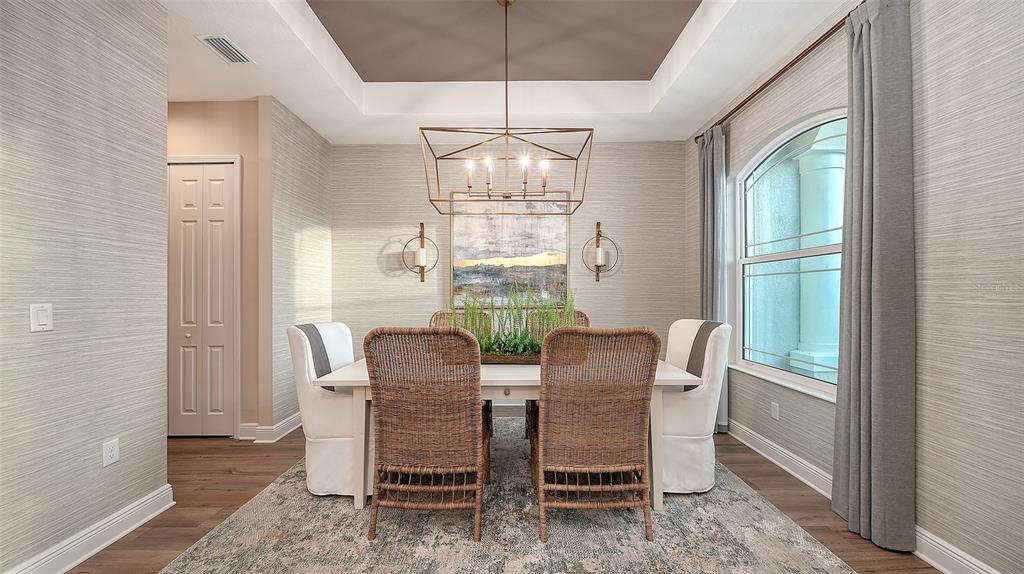 A dining room features a rectangular table, wicker chairs, a chandelier, and textured wallpaper — 3554 RECURVE CIRCLE, SARASOTA, FL