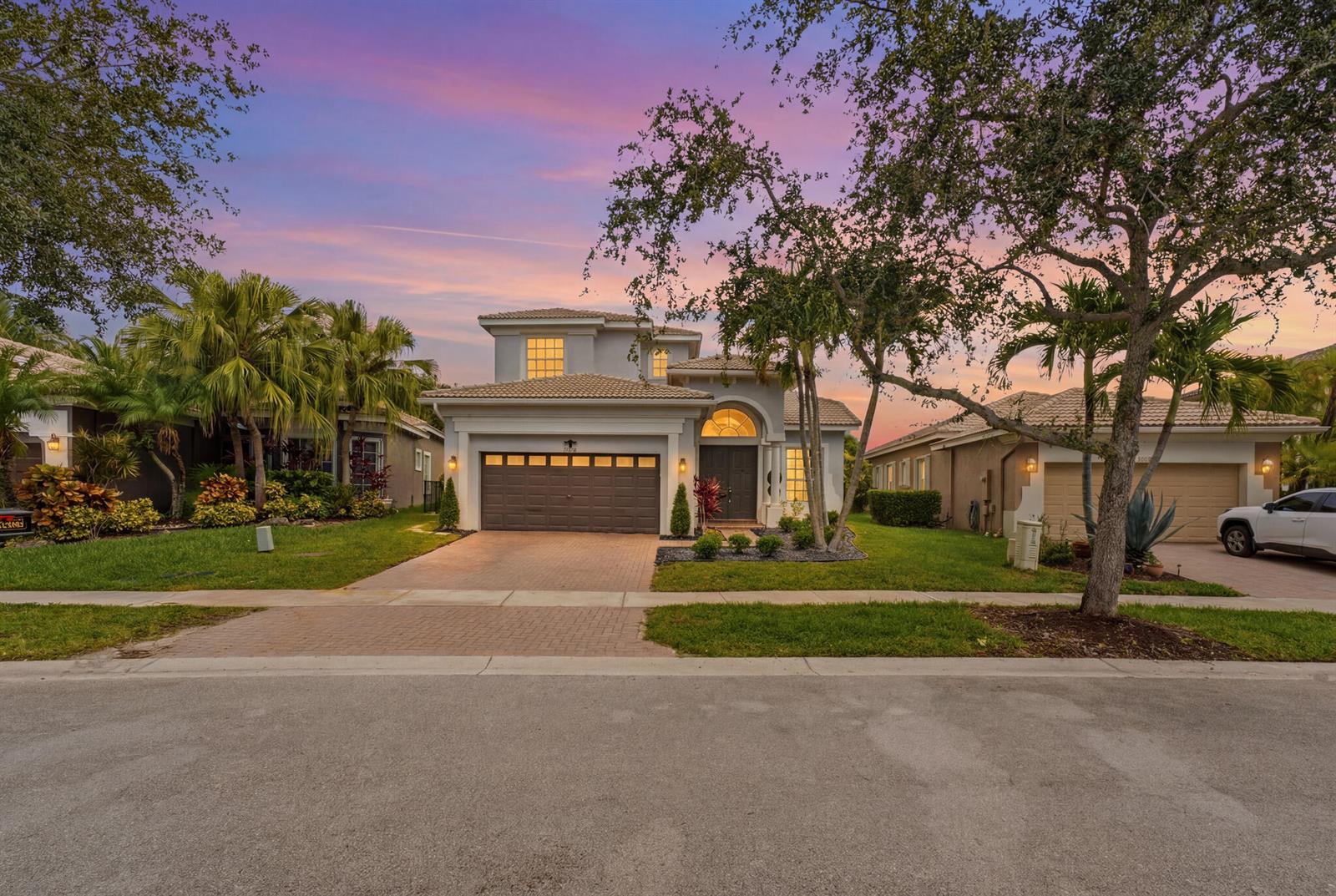 A two-story suburban house with a brown garage and a paved driveway at sunset — 12339 NW 77th Manor, Parkland FL 33076, PARKLAND, FL