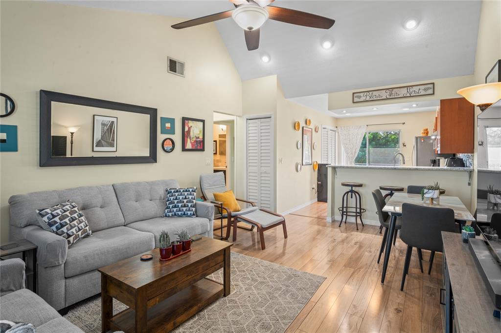 A living room with a gray sofa, wood coffee table, and an open kitchen area — 6424 SPRING FLOWER DRIVE UNIT 24, NEW PORT RICHEY, FL