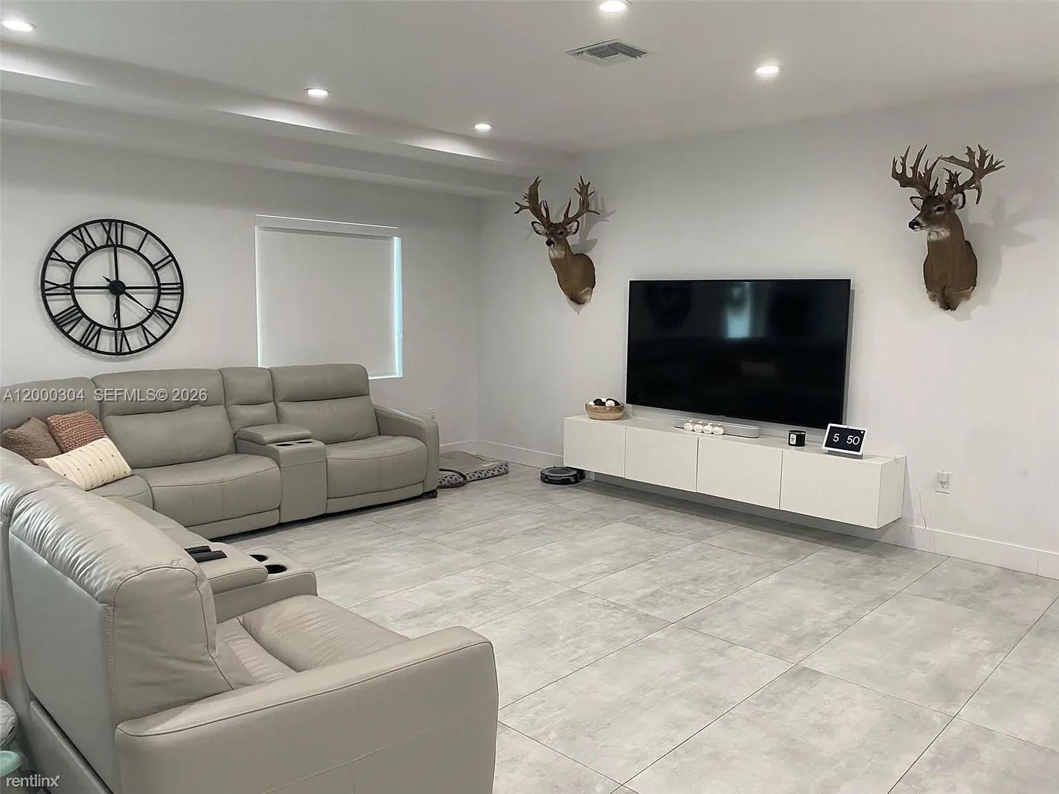 A living room features light gray tile floors, a sectional sofa, and two deer mounts — 1935 SW 24th Ter, Miami FL 33145, MIAMI, FL