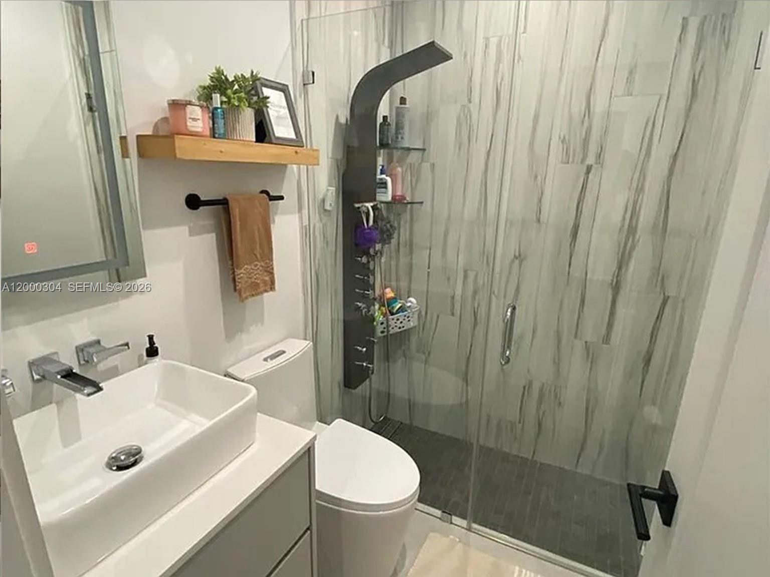 A modern bathroom features a vessel sink, a floating wood shelf, and a glass-enclosed shower — 1935 SW 24th Ter, Miami FL 33145, MIAMI, FL