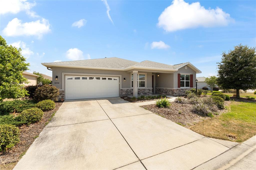 A single-story house with a two-car garage, stone veneer accents, and a concrete driveway — 8898 SW 104TH CIRCLE, OCALA, FL