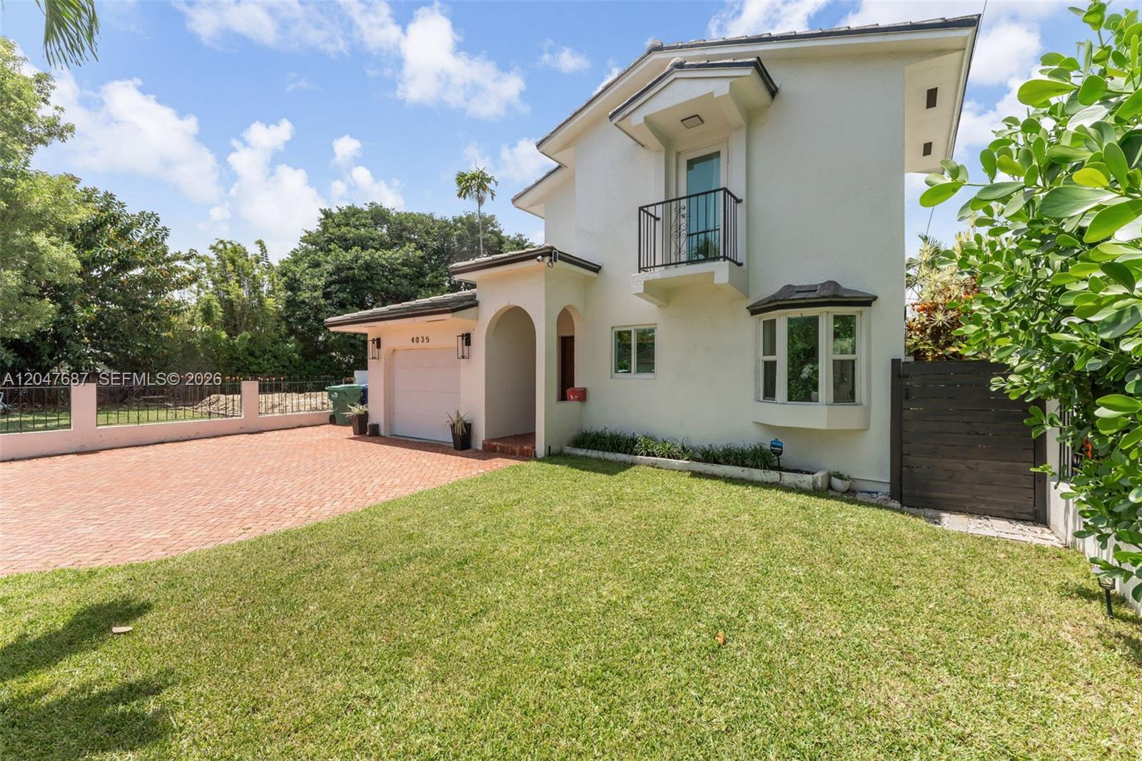 A two-story white house features a brick driveway, a garage, and a small balcony — 4035 SW 14th St, Miami FL 33134, MIAMI, FL