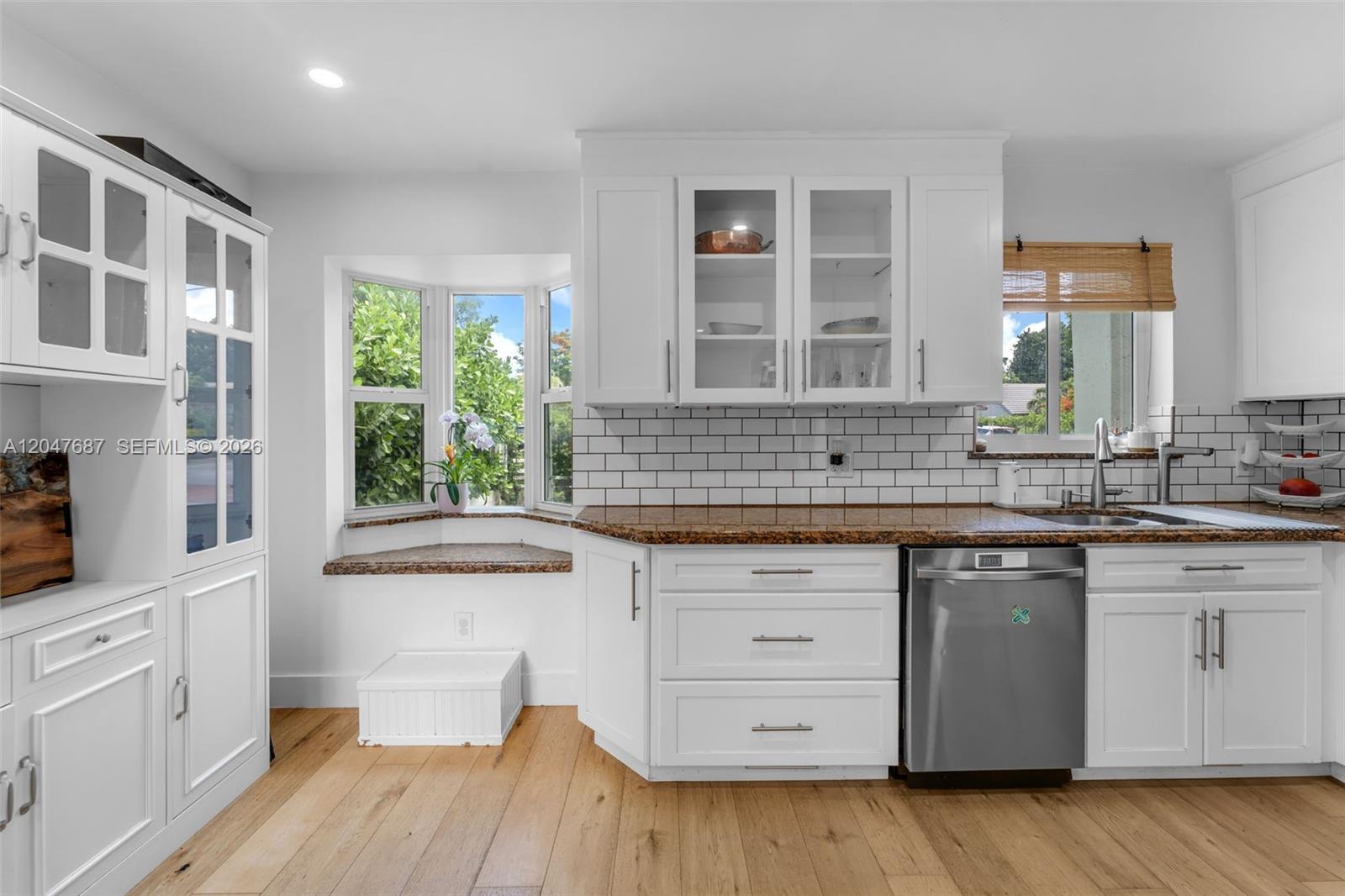 A kitchen features white cabinets, granite countertops, a subway tile backsplash, and a bay window — 4035 SW 14th St, Miami FL 33134, MIAMI, FL