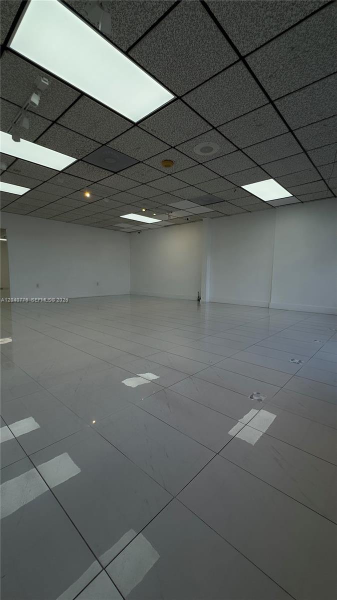 An empty commercial space features white tiled floors, white walls, and a drop ceiling — 3960 W 16th Ave # 204, Hialeah FL 33012, HIALEAH, FL