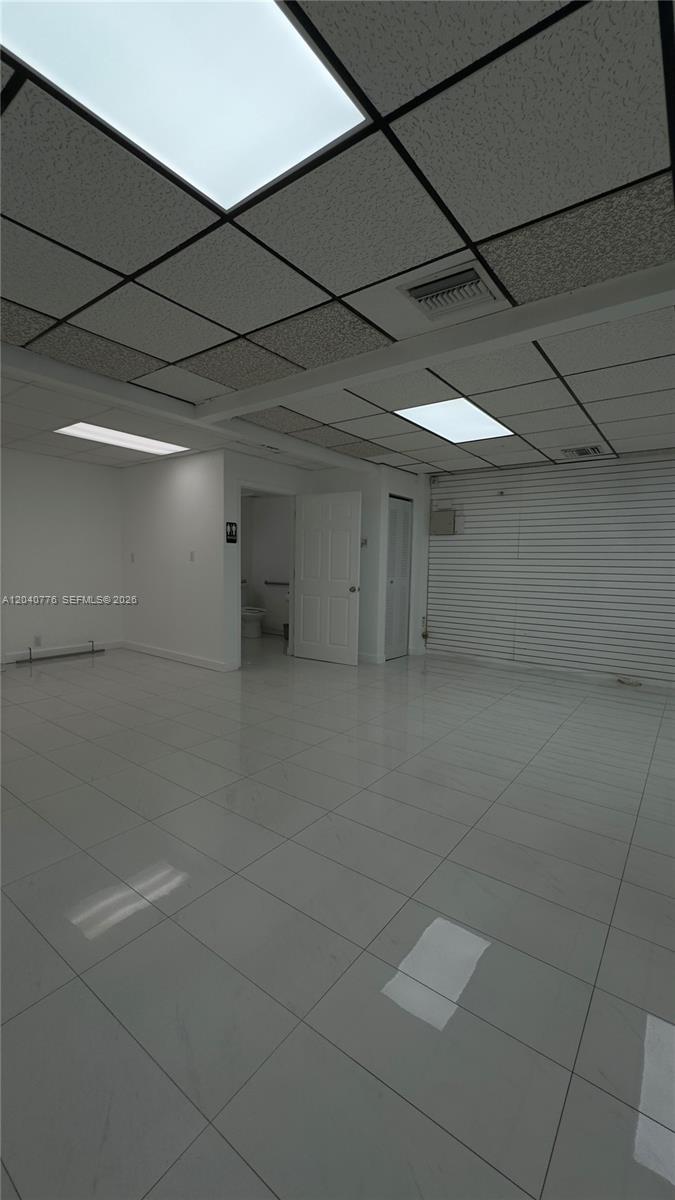 An interior view of a commercial space with white tiled floors and a drop ceiling — 3960 W 16th Ave # 204, Hialeah FL 33012, HIALEAH, FL
