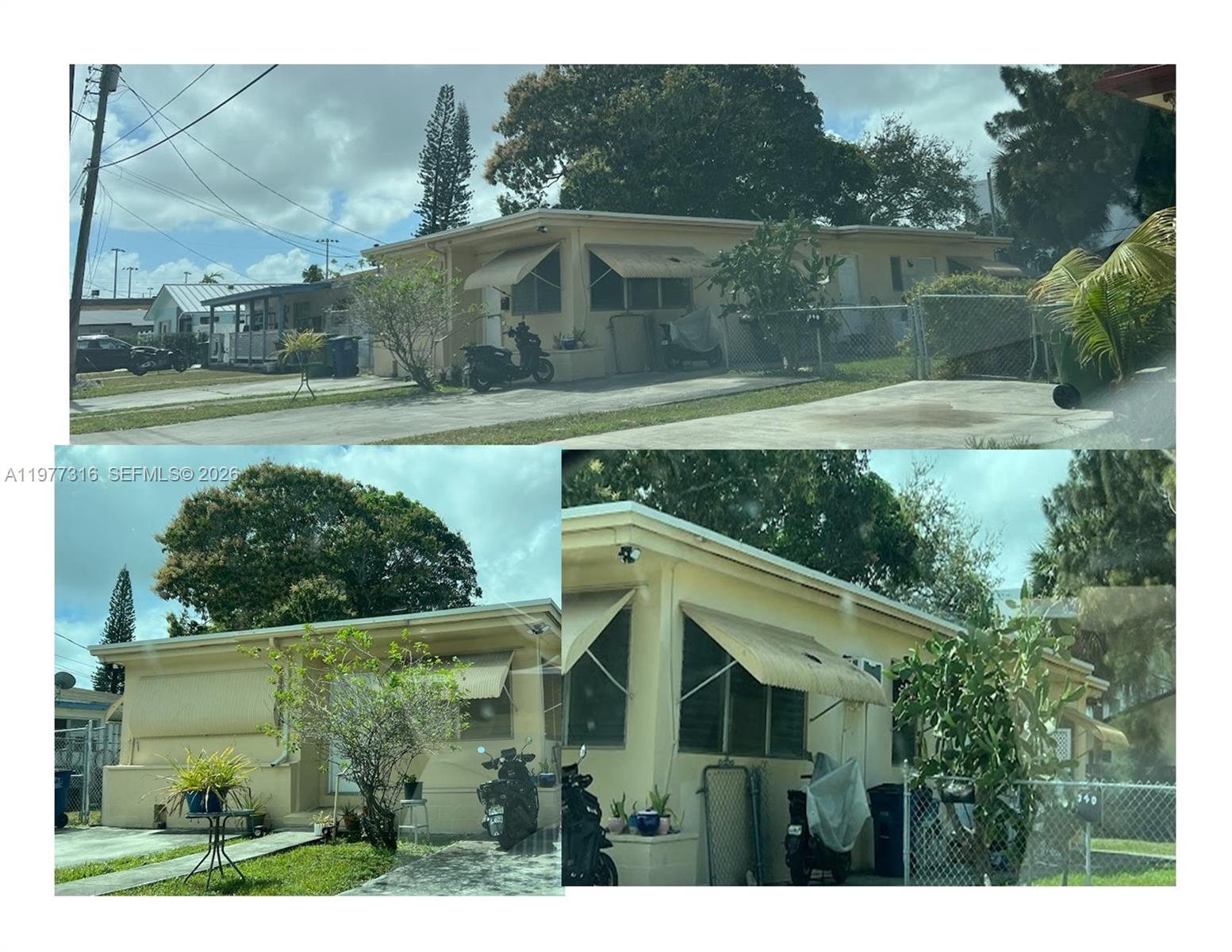 The exterior of a single-story, light-yellow house features metal window awnings and a chain-link fence — 308 SE 4th Ave, Hallandale Beach FL 33009, HALLANDALE BEACH, FL