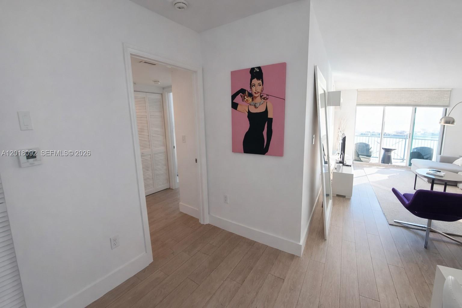 A hallway leads into a living area with light wood floors and a large painting — 90 Alton Rd # 1804, Miami Beach FL 33139, MIAMI BEACH, FL