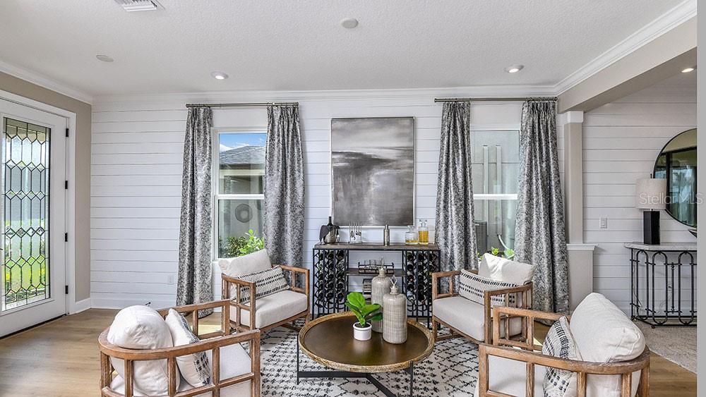 A living room features four armchairs, a central coffee table, and white shiplap walls — 5788 PORTICO PLACE, KISSIMMEE, FL