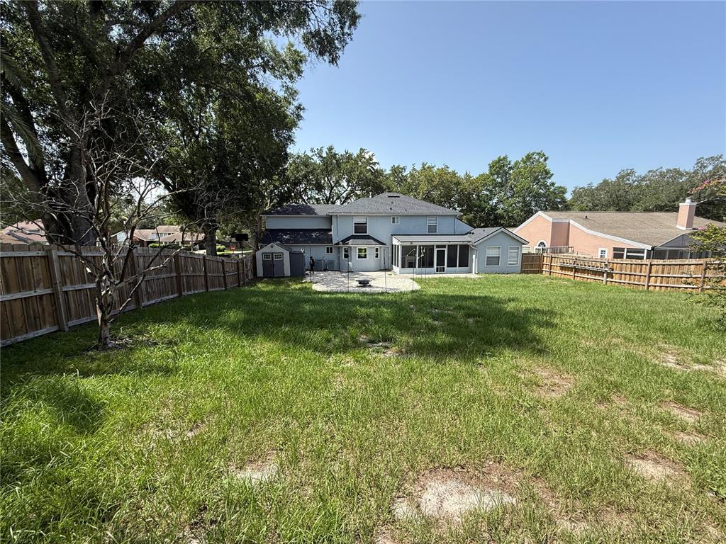 A two-story white brick house with a covered entryway and large trees in the yard — 1927 PALM VIEW DRIVE, APOPKA, FL