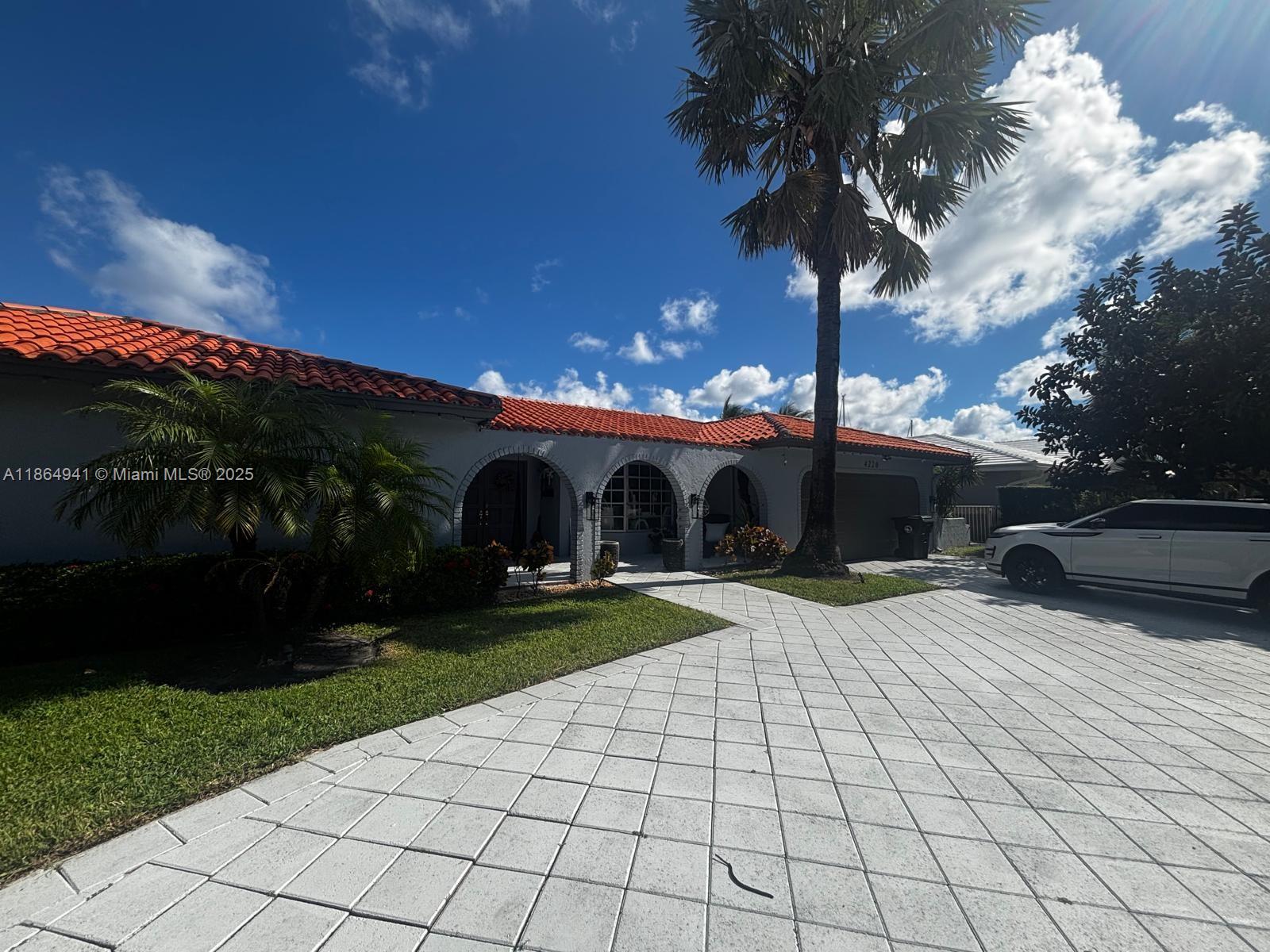 A single-story house with a red tile roof, arched entryways, and a paved driveway — 4220 NE 27th Ave, Lighthouse Point FL 33064, LIGHTHOUSE POINT, FL