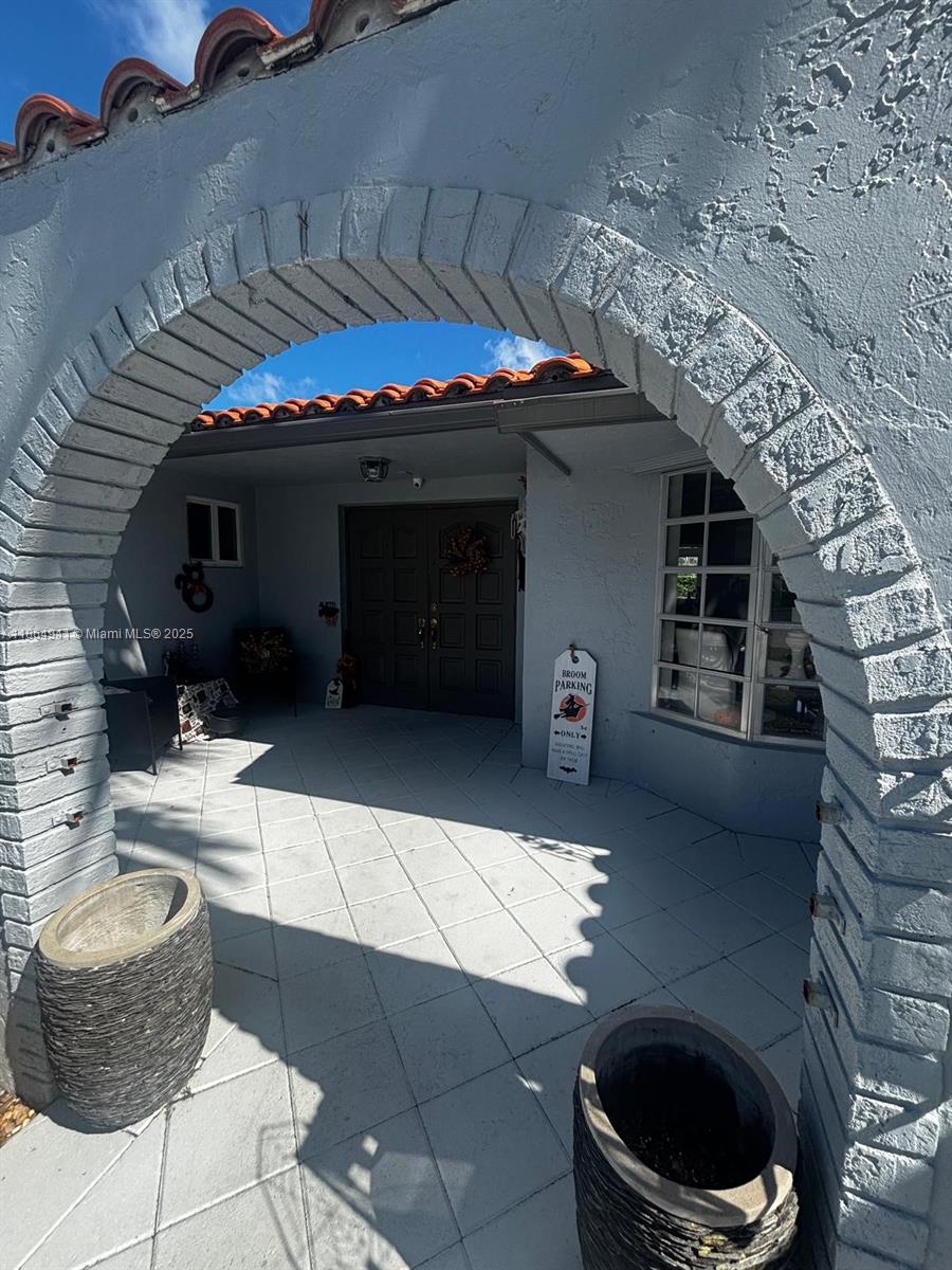 A covered entryway features a stone archway, tiled patio, and a double front door — 4220 NE 27th Ave, Lighthouse Point FL 33064, LIGHTHOUSE POINT, FL