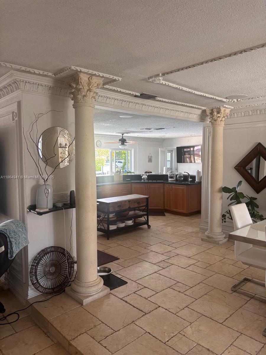 A kitchen with wooden cabinets is framed by two decorative columns in a tiled room — 4220 NE 27th Ave, Lighthouse Point FL 33064, LIGHTHOUSE POINT, FL