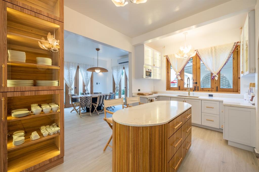 A kitchen features a slatted wood island, white cabinetry, and an adjacent dining area — 1507 MIRSONIA, SAN JUAN, PR