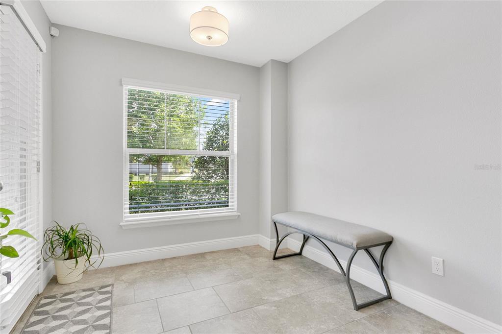 A bright room with light gray walls, tile flooring, a window, and a gray bench — 10534 GREEN IVY LANE, ORLANDO, FL