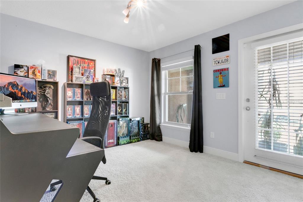 A home office features a desk, a computer, shelves with collectibles, and a glass door — 10534 GREEN IVY LANE, ORLANDO, FL