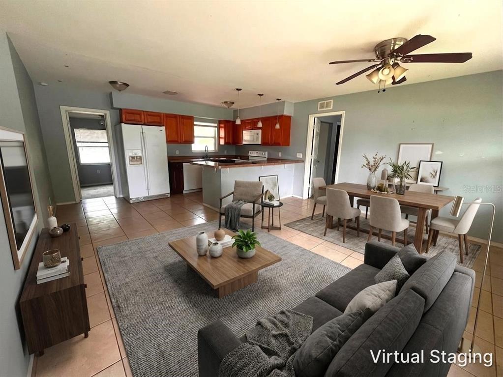 A virtually staged open-concept living and dining area with tile floors and wood cabinets — 731 LAKESIDE DRIVE, LARGO, FL